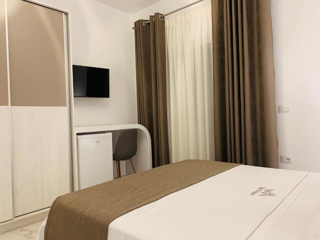 Pokój hotelowy z łóżkiem i lustrem w obiekcie Villa Orkidea w Sarandzie