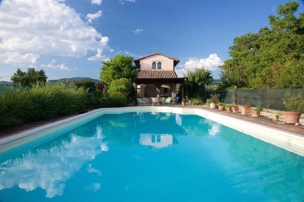 a swimming pool in front of a house at Al Guado di Assisi B&B in Bastia Umbra