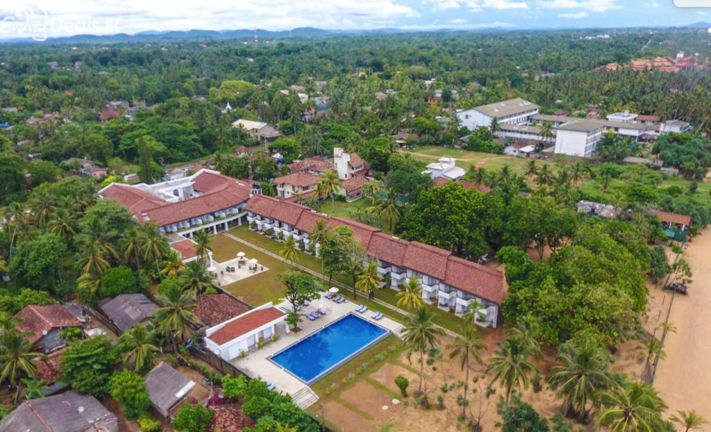 an aerial view of a house with a swimming pool at Hibiscus Beach Hotel & Villas in Kalutara