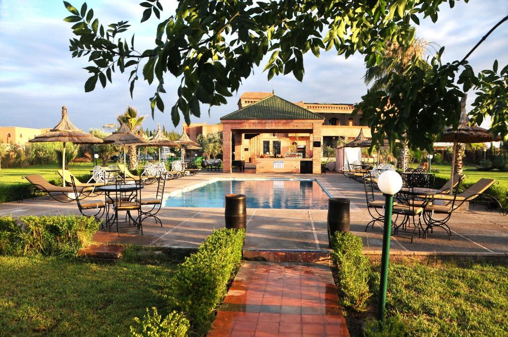 un resort con piscina, tavoli e sedie di Riad Mhidou a Marrakech