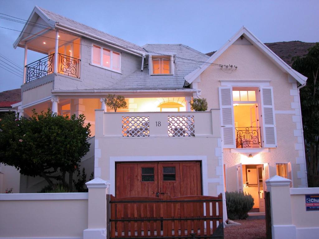 a large white house with a brown garage at Cheviot Place Guest House in Cape Town
