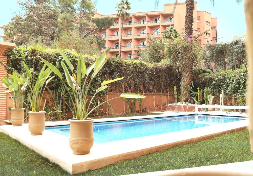 a swimming pool in the yard of a hotel at The Ruby Apartment with Private Swimming Pool - Hivernage Quarter - By Goldex Marrakech in Marrakesh