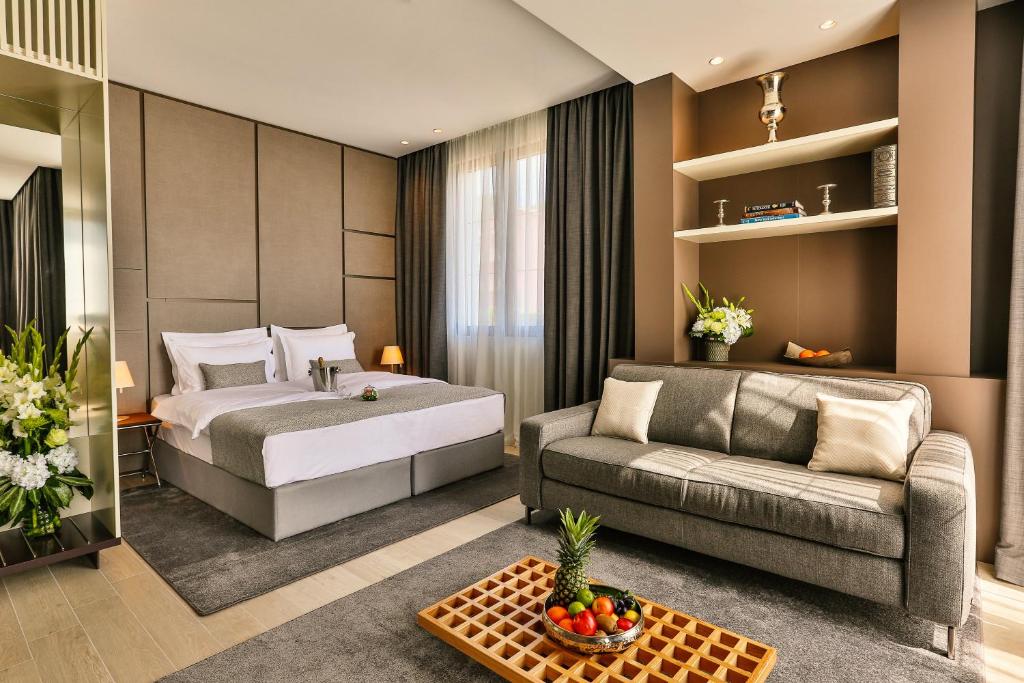 ブドヴァにあるAvanti Hotel & Spaのベッドとソファ付きのホテルルーム
