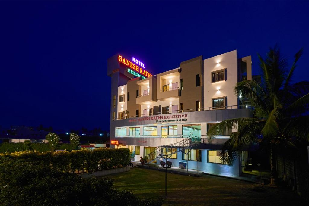 un hotel con un letrero de neón encima en Hotel Ganeshratna Executive, en Kolhapur