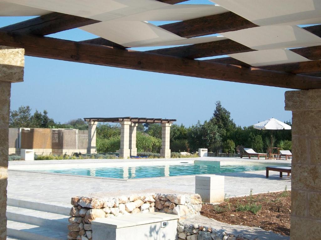 - une piscine avec un pavillon et une table dans l'établissement Casale Calavita, à Santa Cesarea Terme