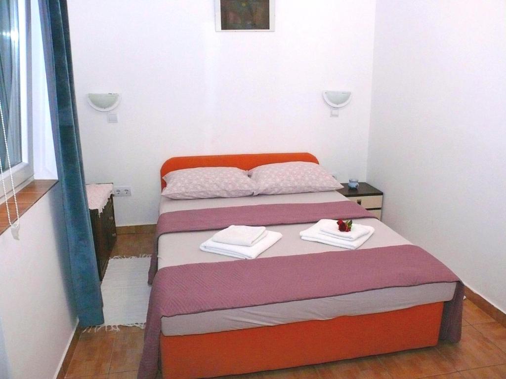ein kleines Zimmer mit einem Bett mit Handtüchern darauf in der Unterkunft Apartments Panonija in Novalja
