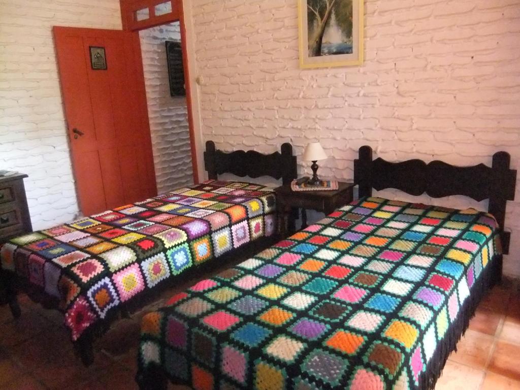 duas camas sentadas uma ao lado da outra num quarto em Eco Pousada Passaredo em São Miguel Arcanjo