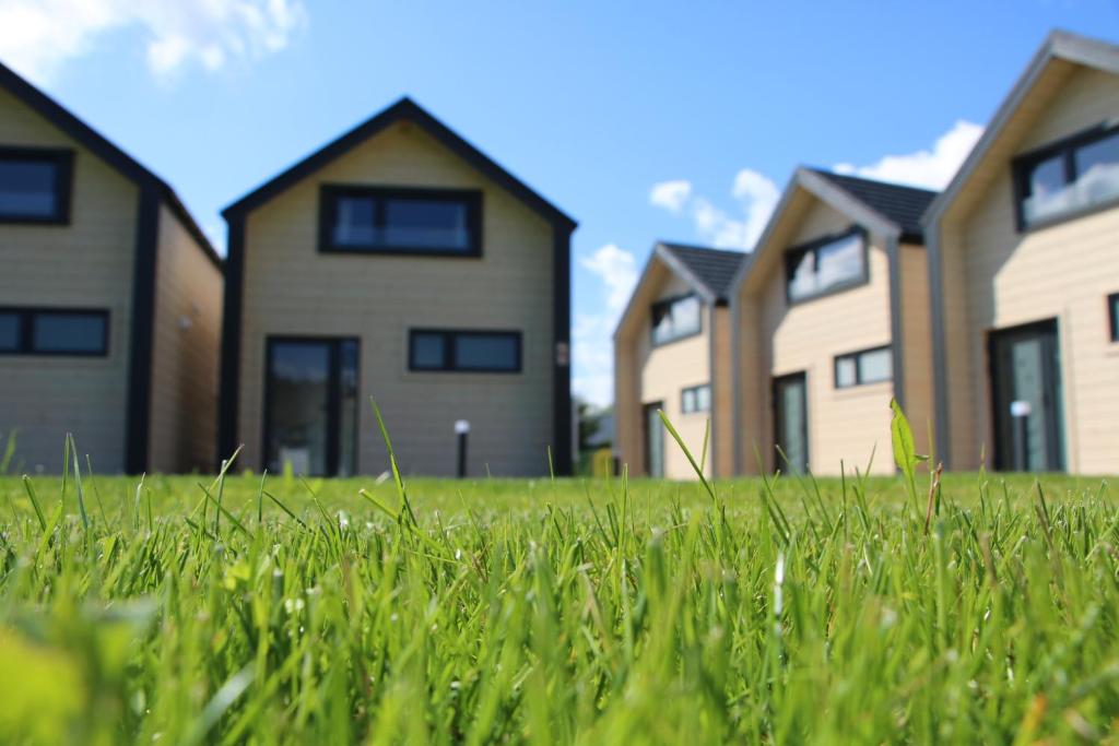 a row of houses in a field of grass at Jachtowa Park in Grzybowo