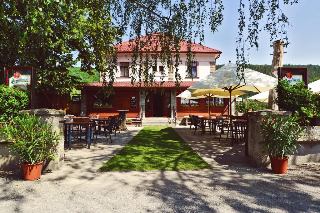 un patio avec des tables et des chaises en face d'un bâtiment dans l'établissement Penzion Karlštejn, à Karlštejn