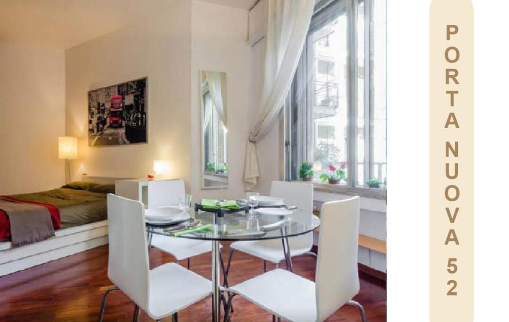 comedor con mesa de cristal y sillas blancas en Appartamento in Centro Milano, en Milán