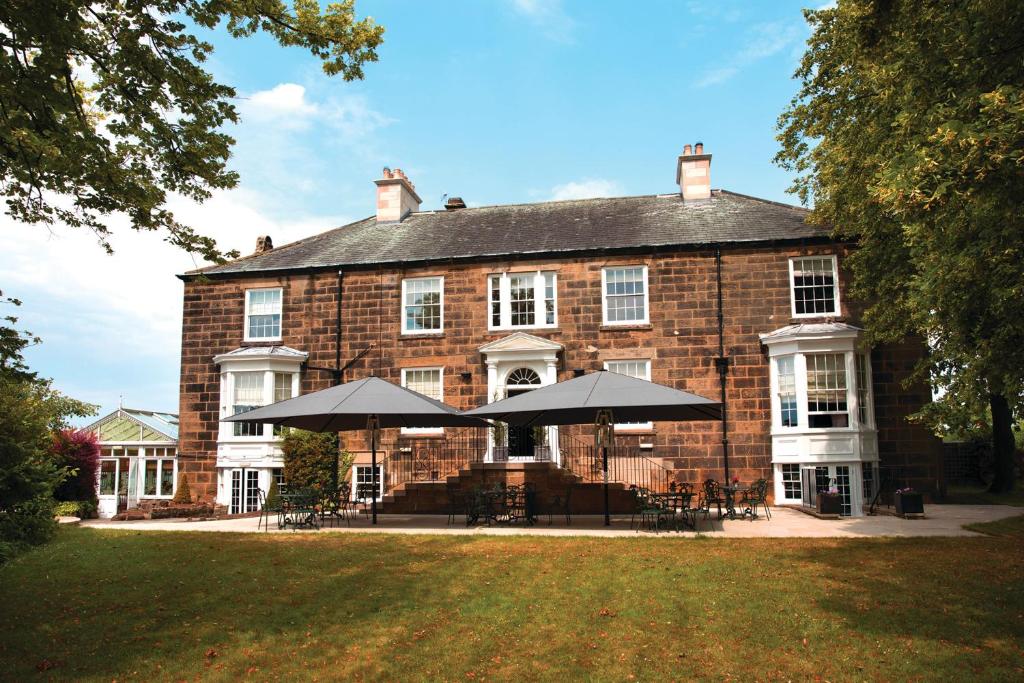 un gran edificio de ladrillo con sombrillas delante en The Cleveland Tontine, en Northallerton