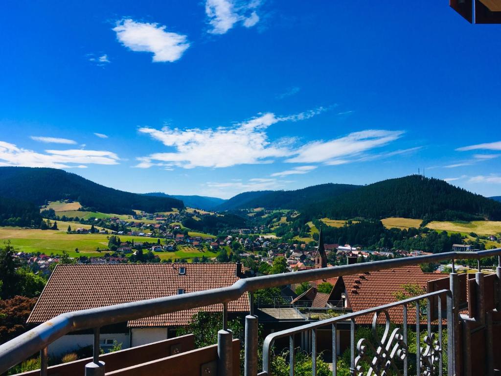 a view of a town from a balcony with mountains at Goldener Hahn Residence in Baiersbronn