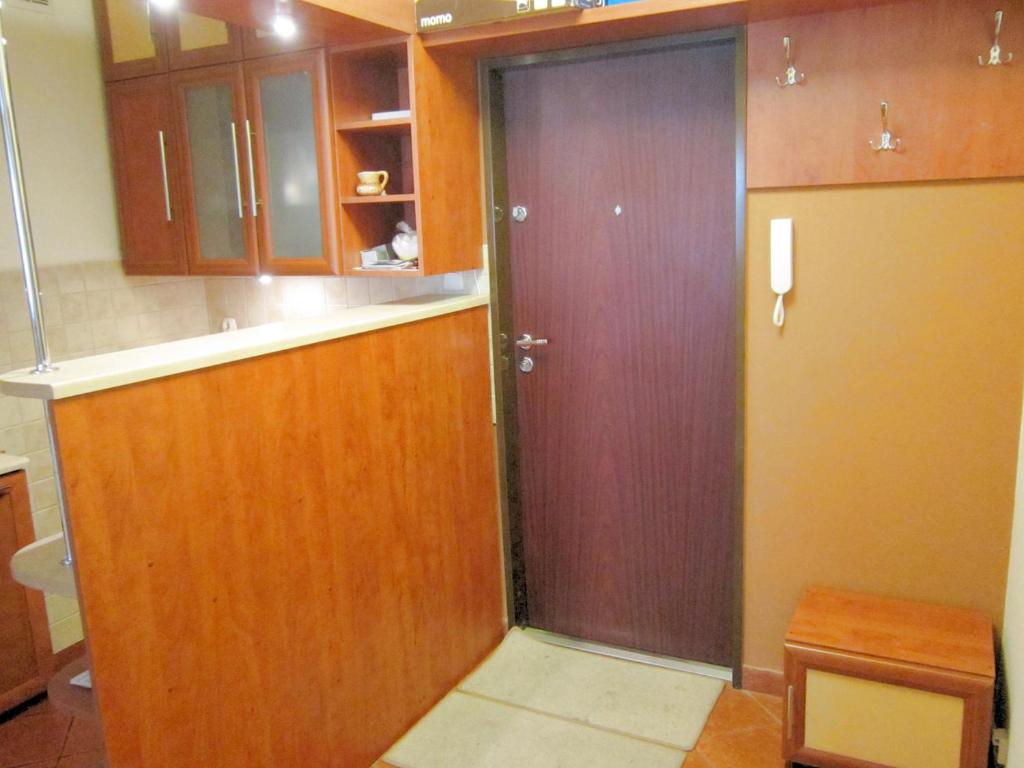 a bathroom with a wooden door in a kitchen at Przytulne i atrakcyjne mieszkanie z pełnym wyposażeniem, dwa pokoje in Skarżysko-Kamienna