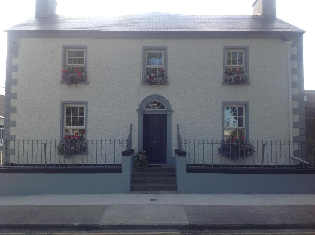 a white house with flower boxes and a door at Harbour House in Tullamore