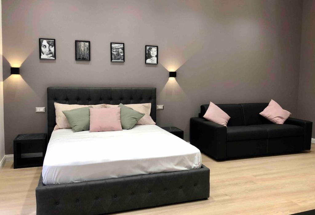 a bedroom with a bed and a black couch at NSH AppartHotel, Napoli Centro in Naples