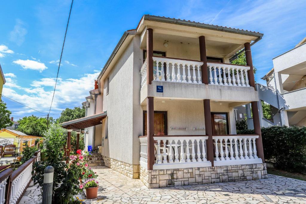 ein Haus mit Balkon auf einer Straße in der Unterkunft Medulin Riviera Apartments Goran in Medulin