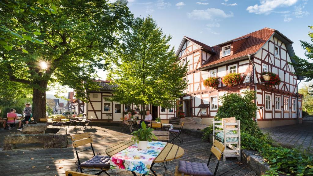 eine Terrasse vor einem Gebäude mit einem Tisch und Stühlen in der Unterkunft Landhotel Gemeindeschänke in Wanfried