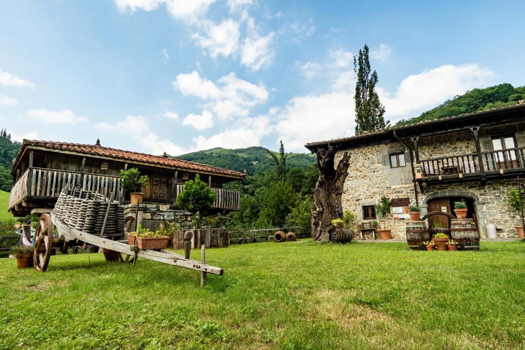 a farm house with a wagon in front of it at Casona de El Castañíu in Serrapio