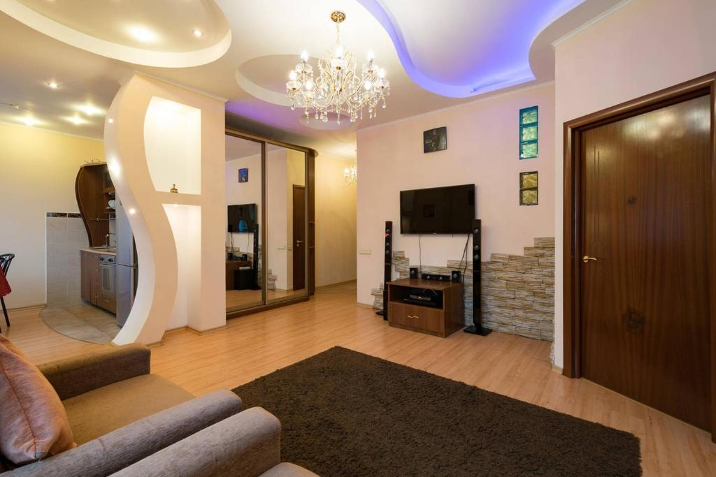 a living room with a couch and a chandelier at Nadezhda Apartments in Keremet Microdistrict in Almaty