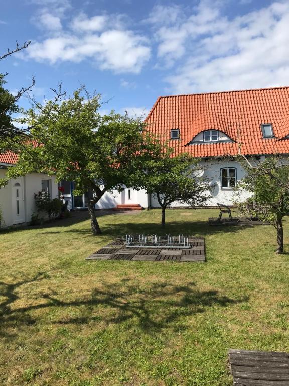 a yard with trees and a building with a red roof at Hafenapartments Zingst in Zingst