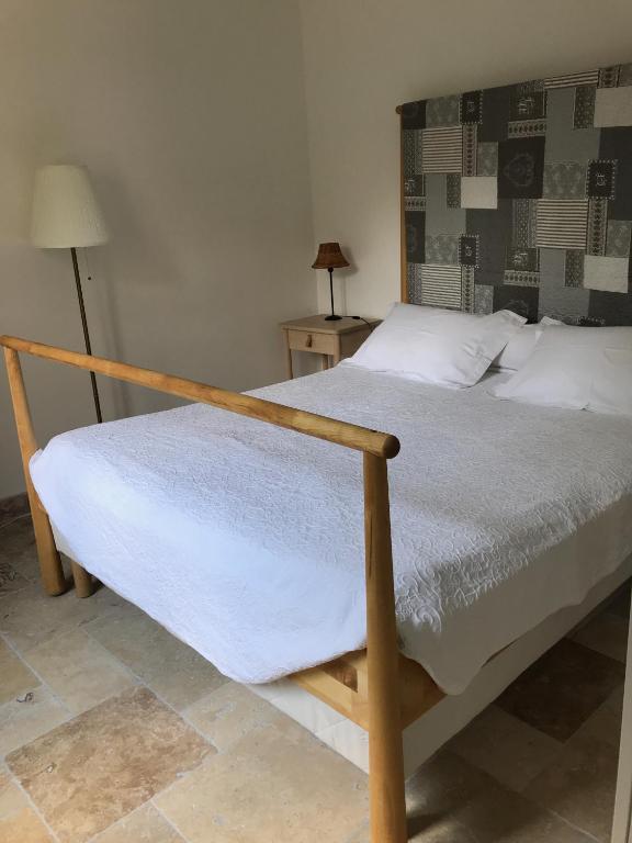 - une chambre avec un lit doté d'un cadre en bois dans l'établissement Annexe Bastide du Paradou, à Moustiers-Sainte-Marie