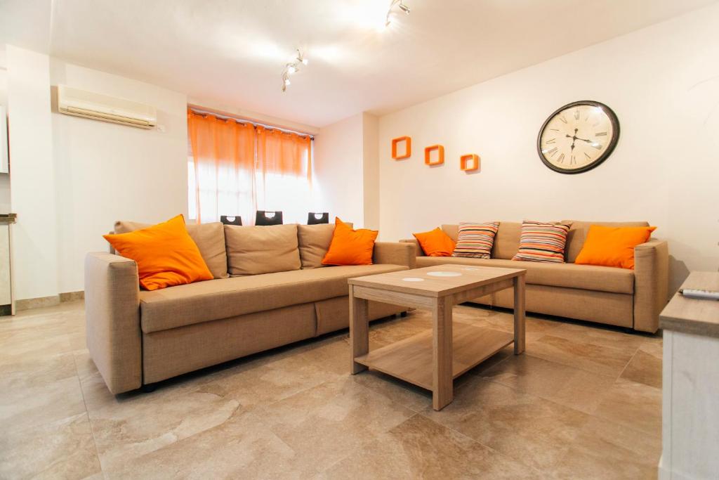 uma sala de estar com dois sofás e um relógio na parede em Wide and diaphanous- 3Bd 2Bth- Alcázar em Sevilha