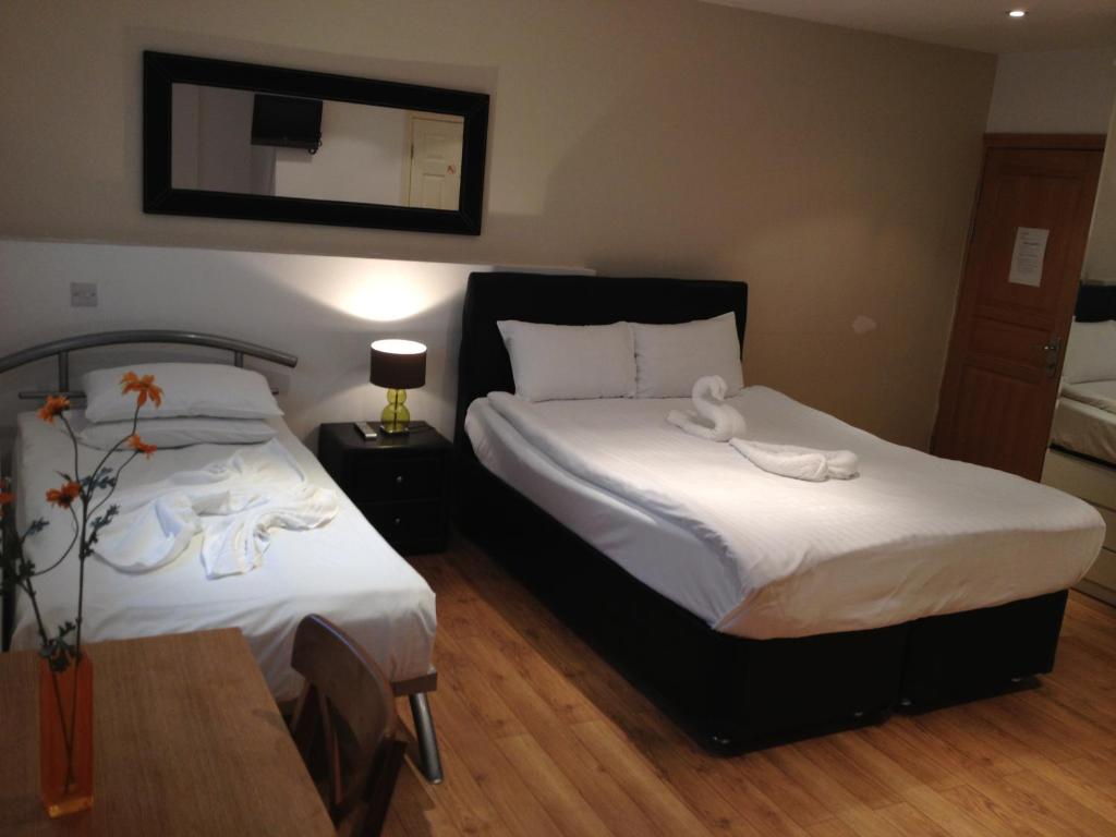 um quarto com 2 camas e toalhas brancas em NOX West End Lane I em Londres