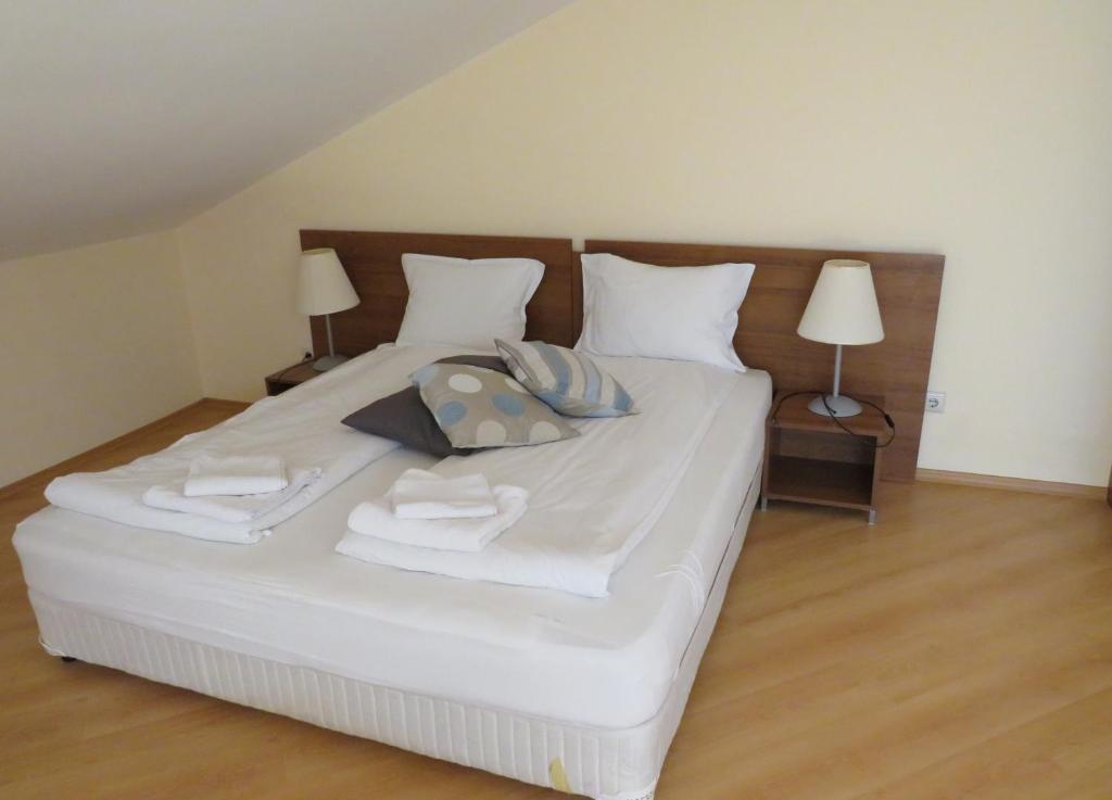 uma grande cama branca com toalhas e almofadas em Villa Park Studio Apartment nr 409 em Borovets