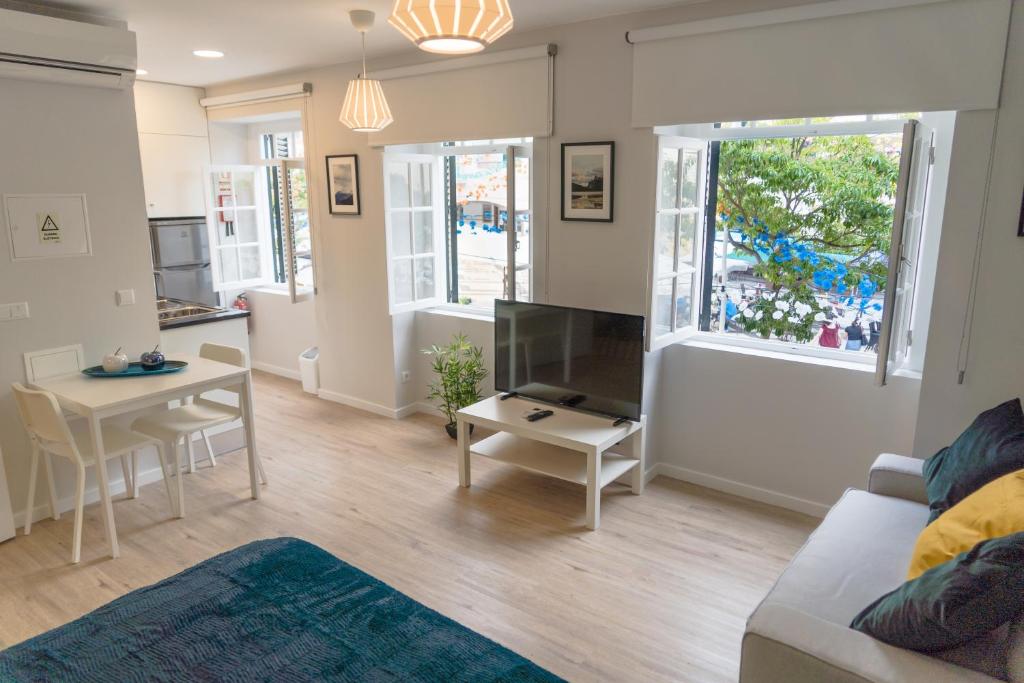 una sala de estar con un sofá y una mesa en Funchal Village Studios, en Funchal