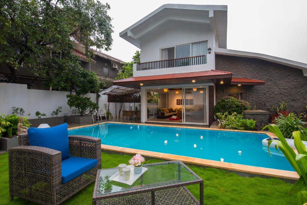 una piscina en el patio trasero de una villa en EL Lodge by StayVista - Pool, lawn, and a charming gazebo for your perfect getaway en Lonavala