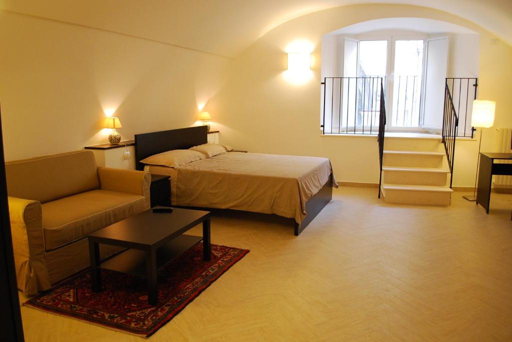 a bedroom with a bed and a couch and a window at Il Purgatorio in Barletta