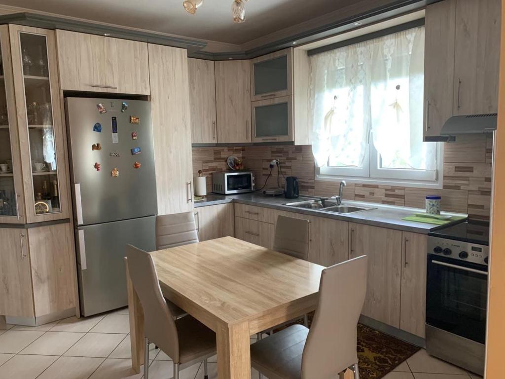 kuchnia z drewnianym stołem i lodówką w obiekcie Rania House w mieście Limenas