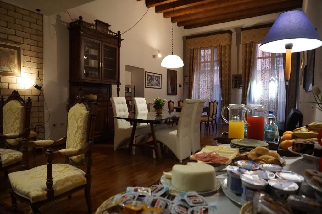 una sala de estar con una mesa con comida. en PALAZZO FULGHER, en Cagliari