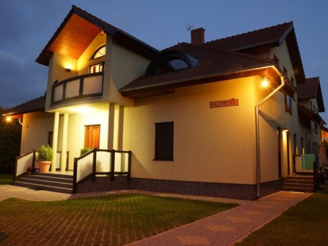 Una gran casa blanca con luces encendidas. en Dom Gościnny Klemens en Dębki