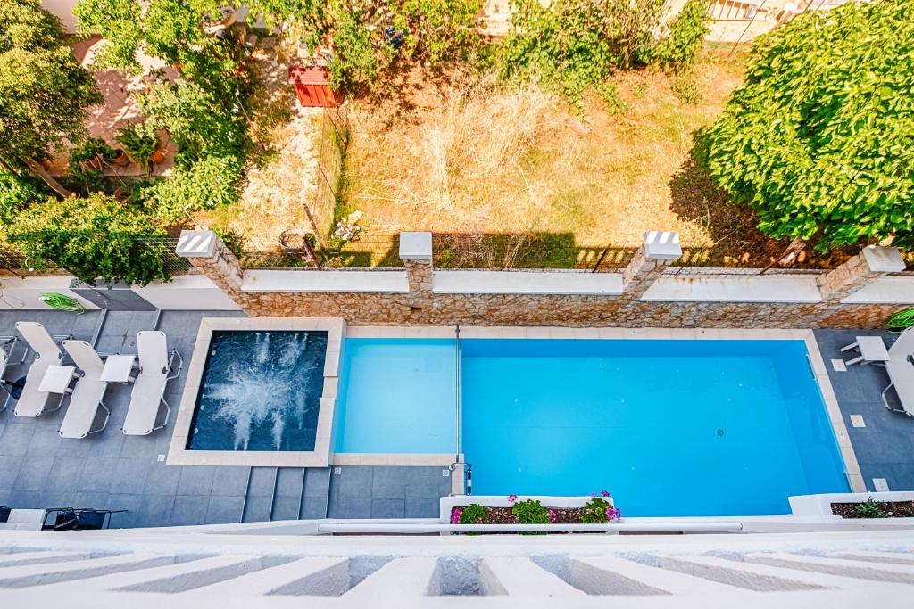 une piscine bleue avec des chaises blanches et une photo dans l'établissement Alexis Hotel, à La Canée
