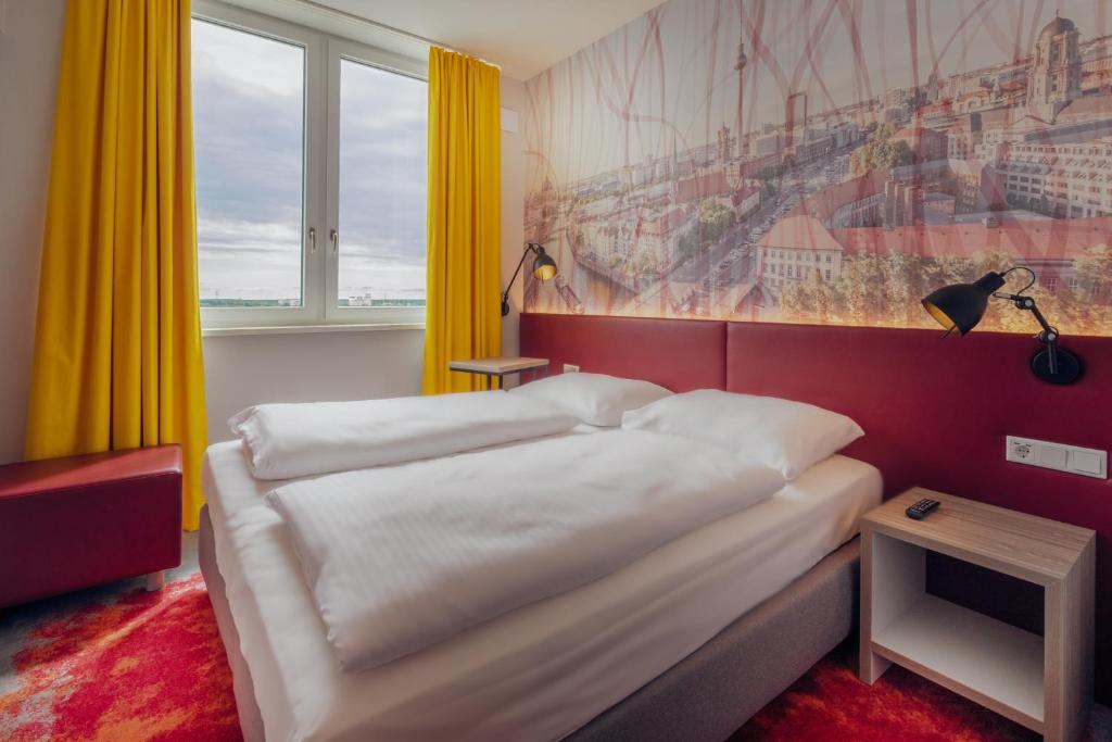 a hotel room with a bed and a painting on the wall at Campanile Berlin Brandenburg Airport in Schönefeld