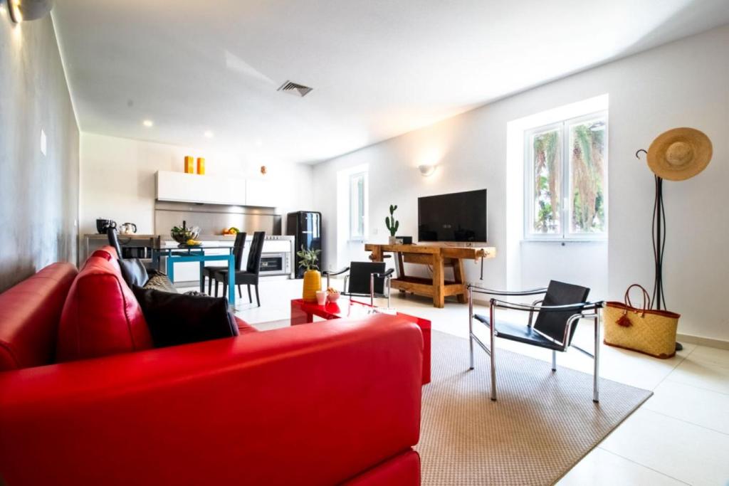a living room with a red couch and a table at Casa Giulia - Apartment beachfront with 2 bedrooms, air conditioning and private parking, just 30 meters from the beach in Sestri Levante