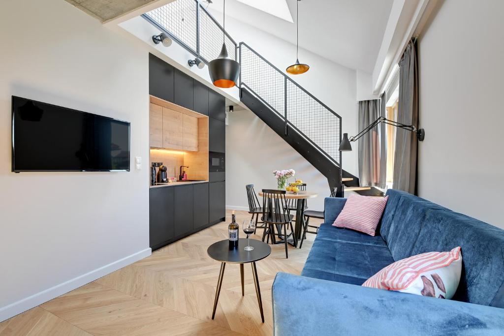 a living room with a blue couch and a table at Pogodna Apartments in Sopot