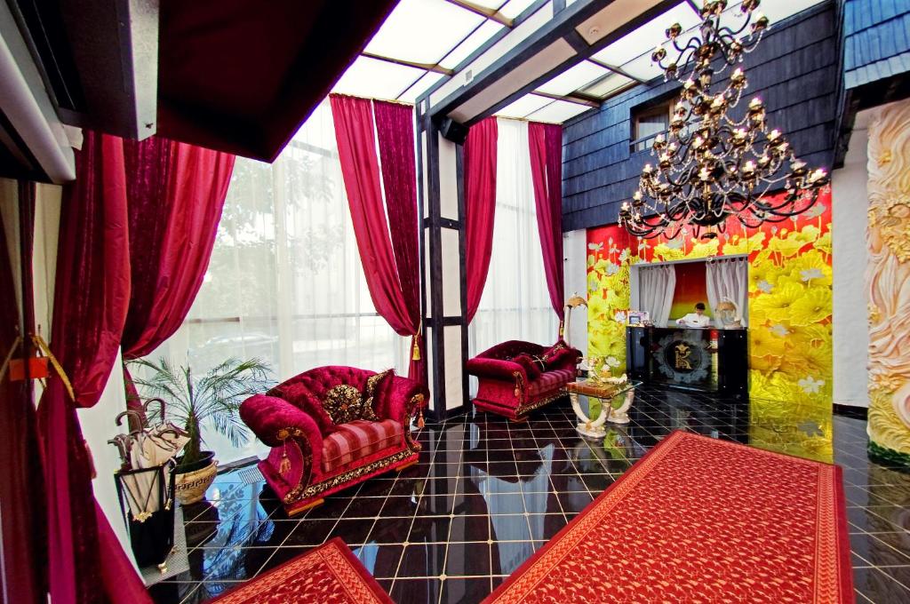 een woonkamer met rode stoelen en een kroonluchter bij Deluxe Hotel Kupava in Lviv