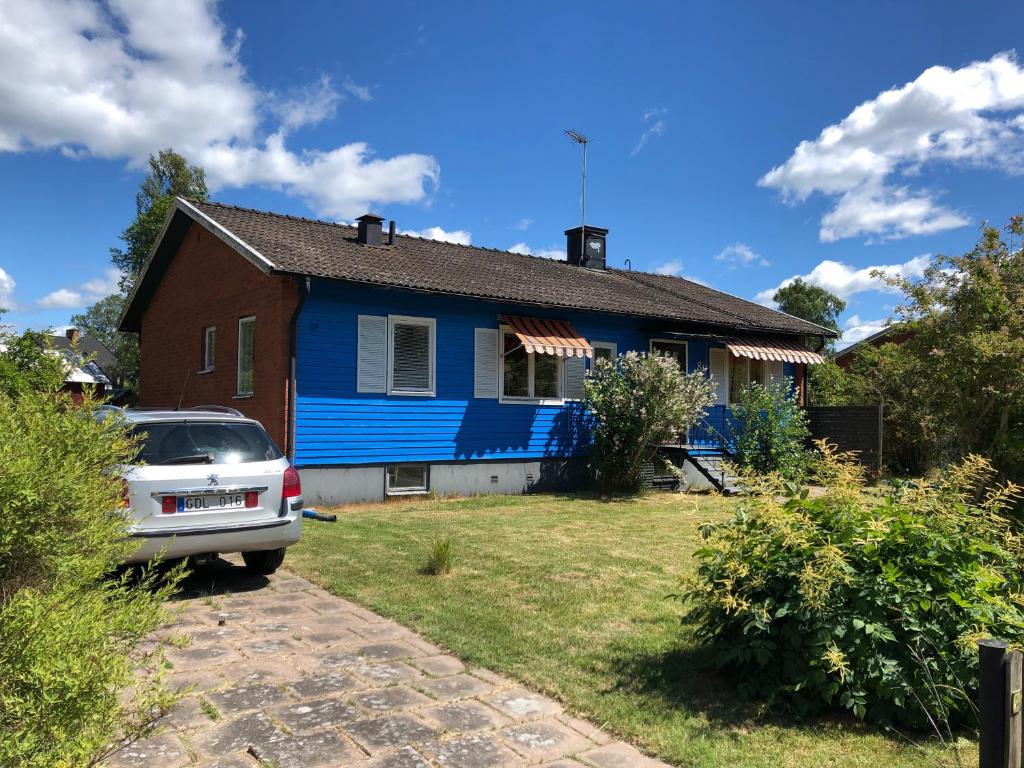 een blauw huis met een auto ervoor geparkeerd bij Boda in Boda