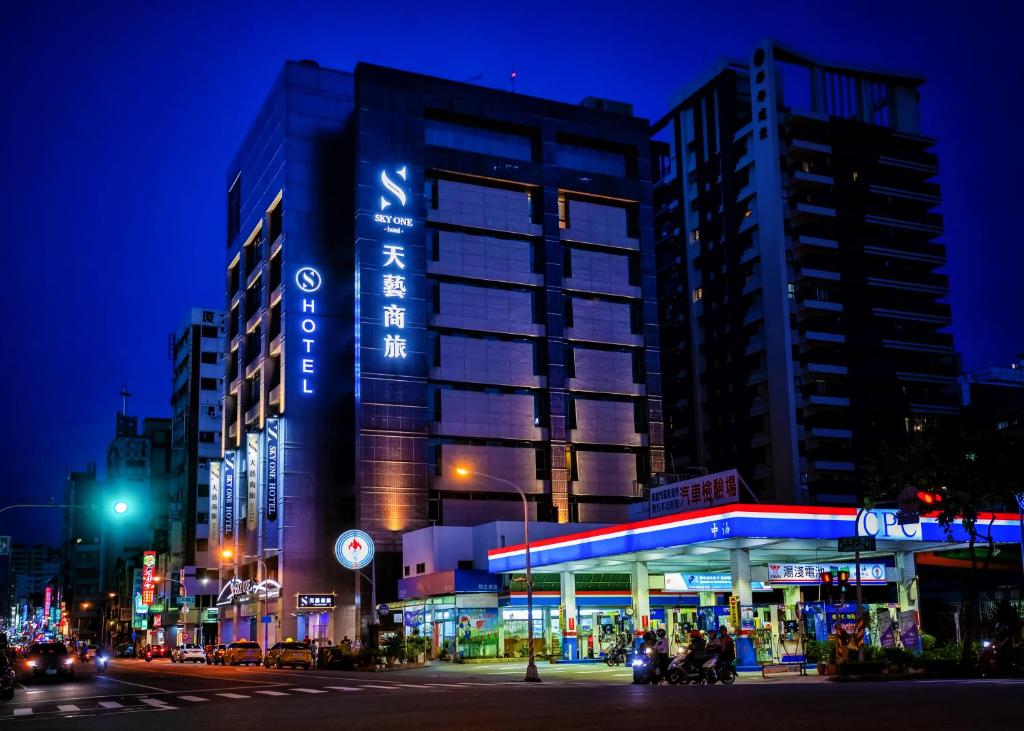 a building with a gas station on a city street at night at Skyone Hotel in Kaohsiung