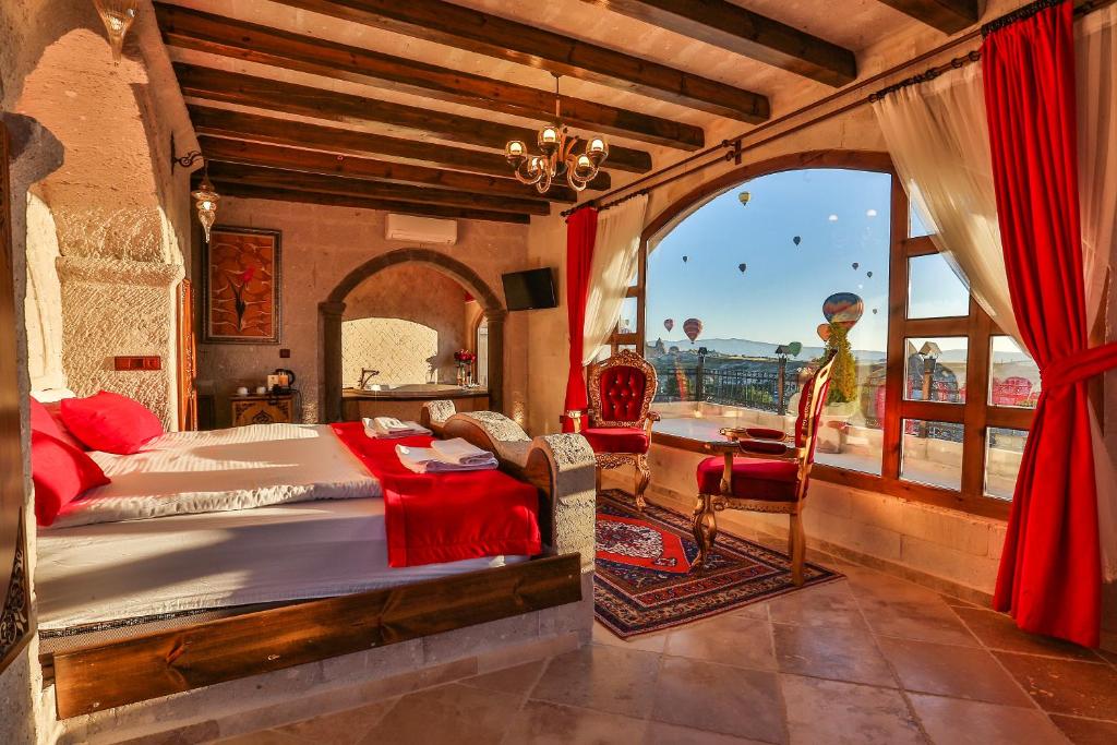 a bedroom with a bed and a large window at Cappadocia Inn Cave Hotel in Göreme