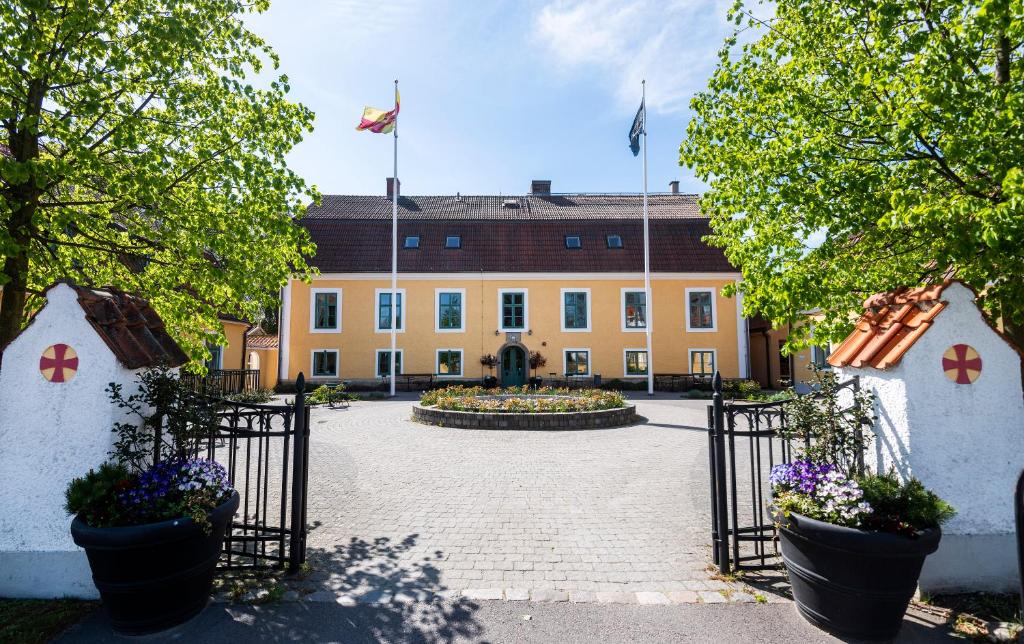 - l'entrée d'un bâtiment avec une cour fleurie dans l'établissement Stiftsgården Åkersberg, à Höör