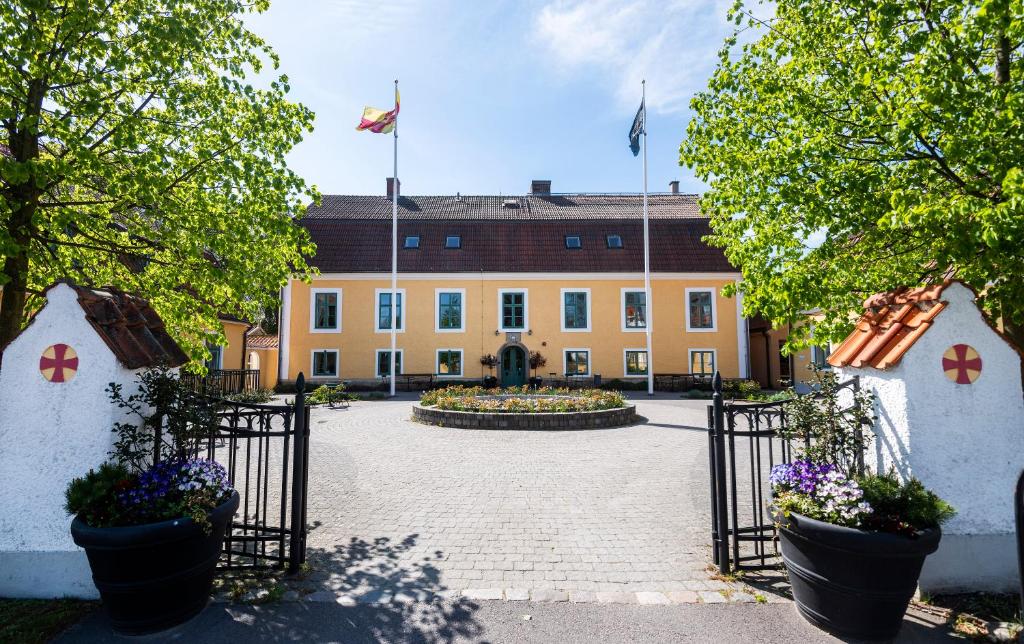 an entrance to a building with a courtyard with flowers at Stiftsgården Åkersberg in Höör