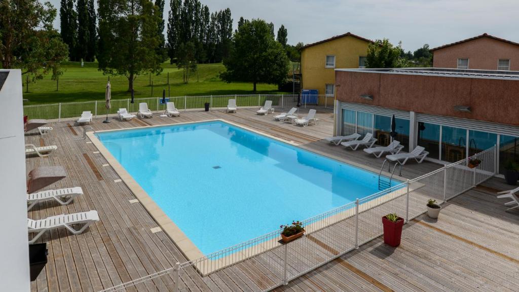 an overhead view of a swimming pool with chairs and a building at Vacancéole - Domaine du Green in Rivières