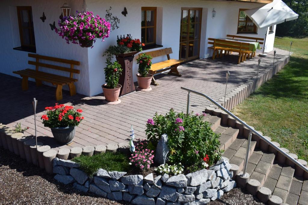 eine Terrasse mit Blumen und Pflanzen vor einem Haus in der Unterkunft Ferienwohnung Kagerbauer Christiane in Lindberg