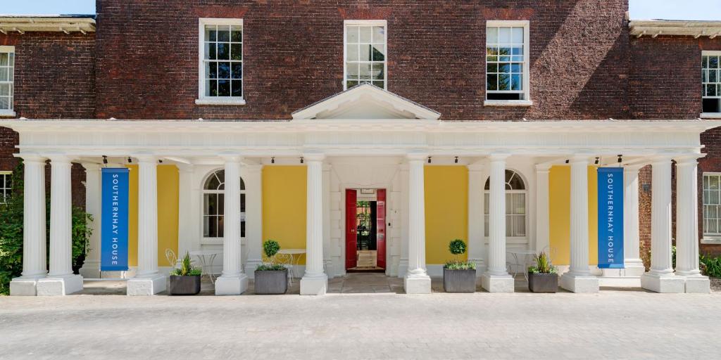 um grande edifício de tijolos com uma porta vermelha e amarela em Southernhay House Hotel em Exeter