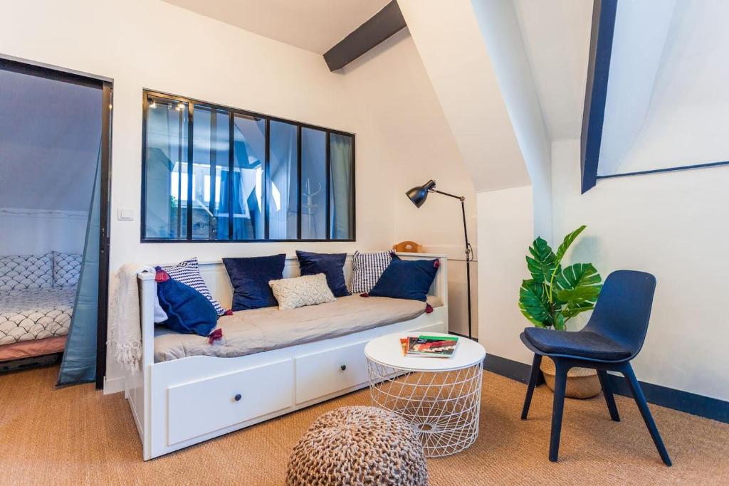 un salon avec un canapé et une chaise dans l'établissement Greeter-Bel appartement au pied des falaises d'Etretat, à Étretat