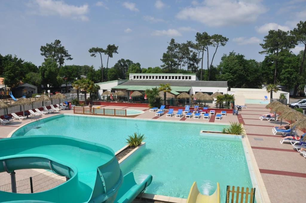 a pool at a resort with lounge chairs at Camping Le California in Saint-Jean-de-Monts