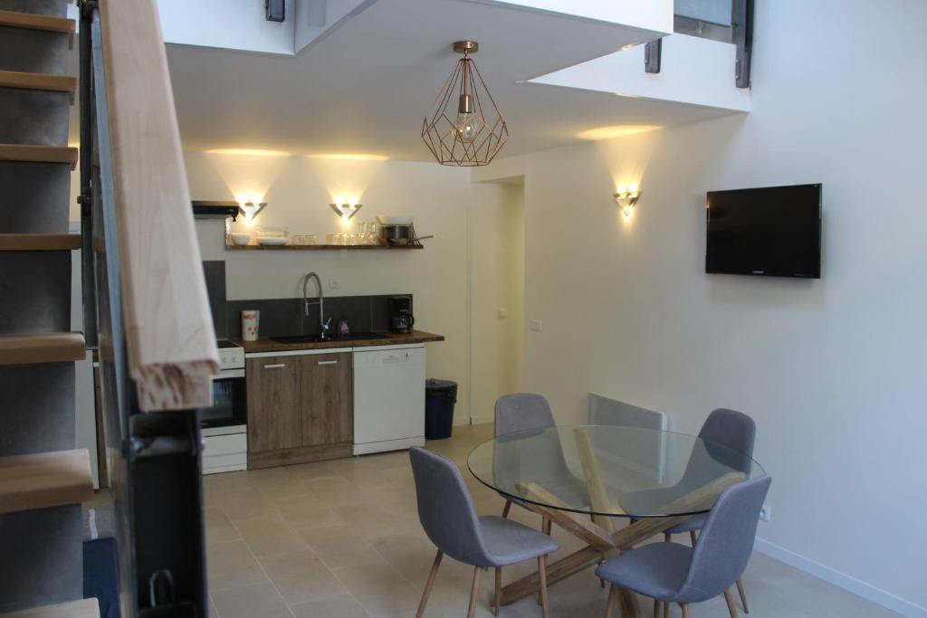 a kitchen and dining room with a glass table and chairs at Riders Apartments in Le Bourg-dʼOisans